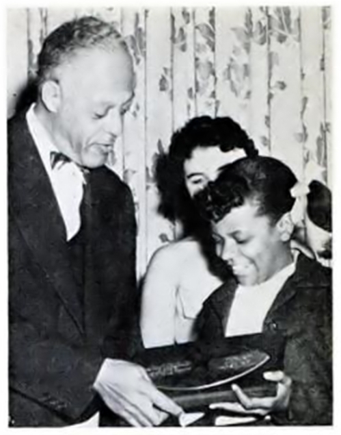 November 3, 1955, Jet Magazine:  "Pigskin Club Cites Spelling Queen:  Guest at the Washington (D.C.) Pigskin Club banquet, 12-year-old Gloria Lockerman, the Baltimore spelling whiz who won $16,000 on a TV quiz show, is presented the Pigskin Club Award for achievement in spelling by Dr. C. Herbert Marshall.