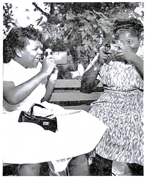 Taking careful aim at each other with their cameras, TV spelling whiz kid Gloria Lockerman and gospel singer Mahalia Jackson get snapshots for their personal collection during a meeting in Chicago.  Gloria, 13, came to town to head the annual Bud Billikin parade. - August 23, 1956 - Jet Magazine